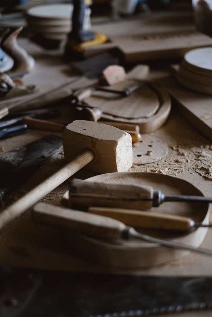 A variety of woodworking tools scattered on a workbench in a workshop setting.